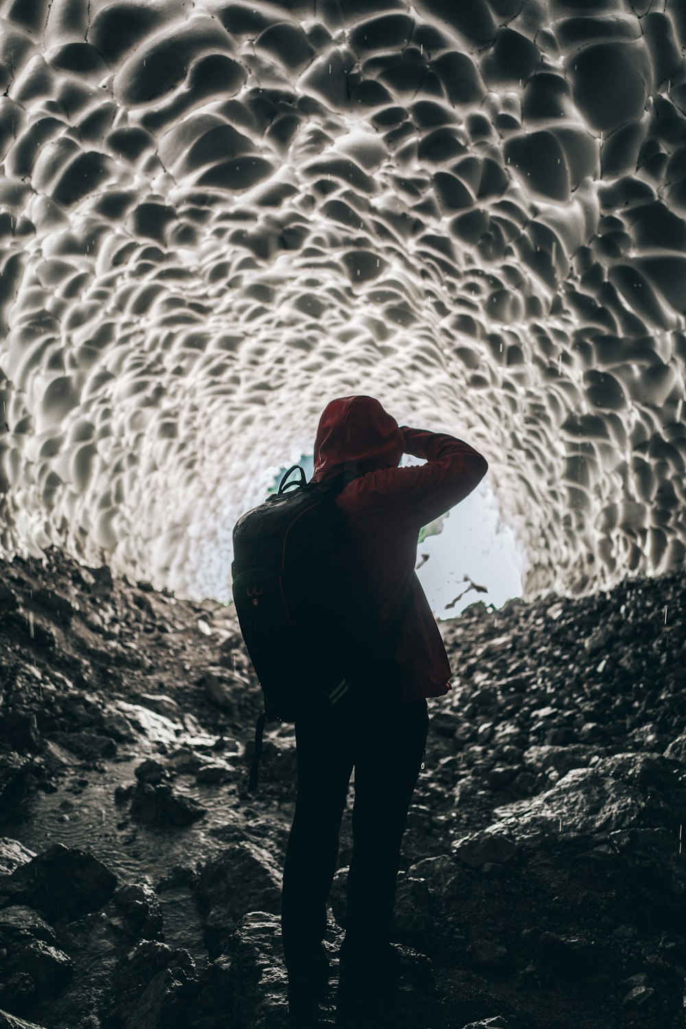 Person mit Rucksack in der Höhle