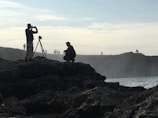 Workshop participants setting up cameras on a rocky ridge under a clear blue sky.