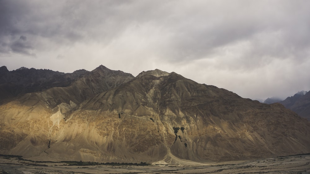 brown mountain near body of water