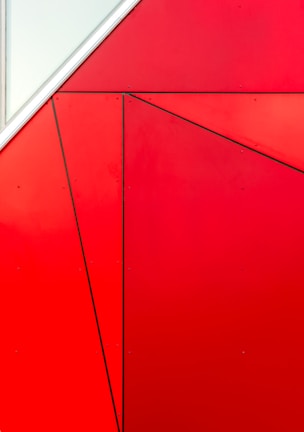 Close-up of a bold, geometric constructivist painting with vivid reds and blacks.