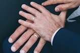 two man's hands wearing gold-colored wedding rings