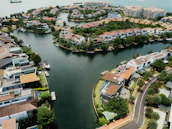 Aerial view of a cluster of modern floating homes surrounded by clear blue water.