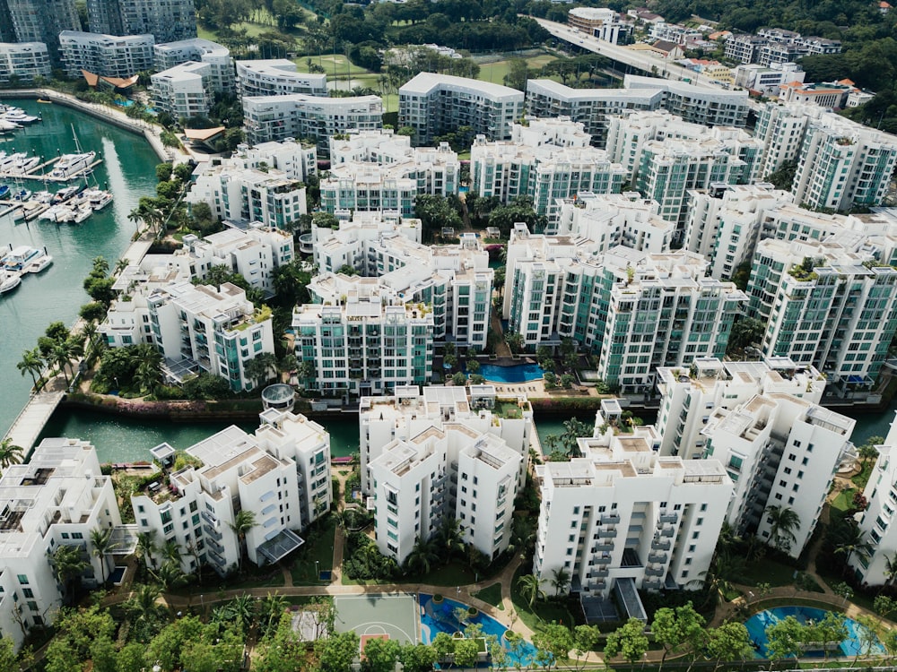 Photographie aérienne de bâtiments en béton blanc au bord d’un plan d’eau pendant la journée