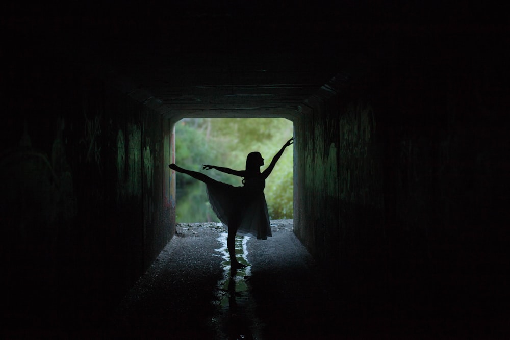 Silhouette einer Frau, die Ballett bei schlechten Lichtverhältnissen fotografiert