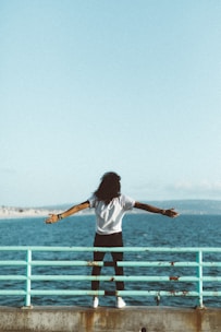woman standing in front of sea under clear blue sky