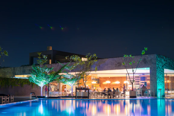 Modern outdoor pool area with elegant decking and soft lighting at dusk.