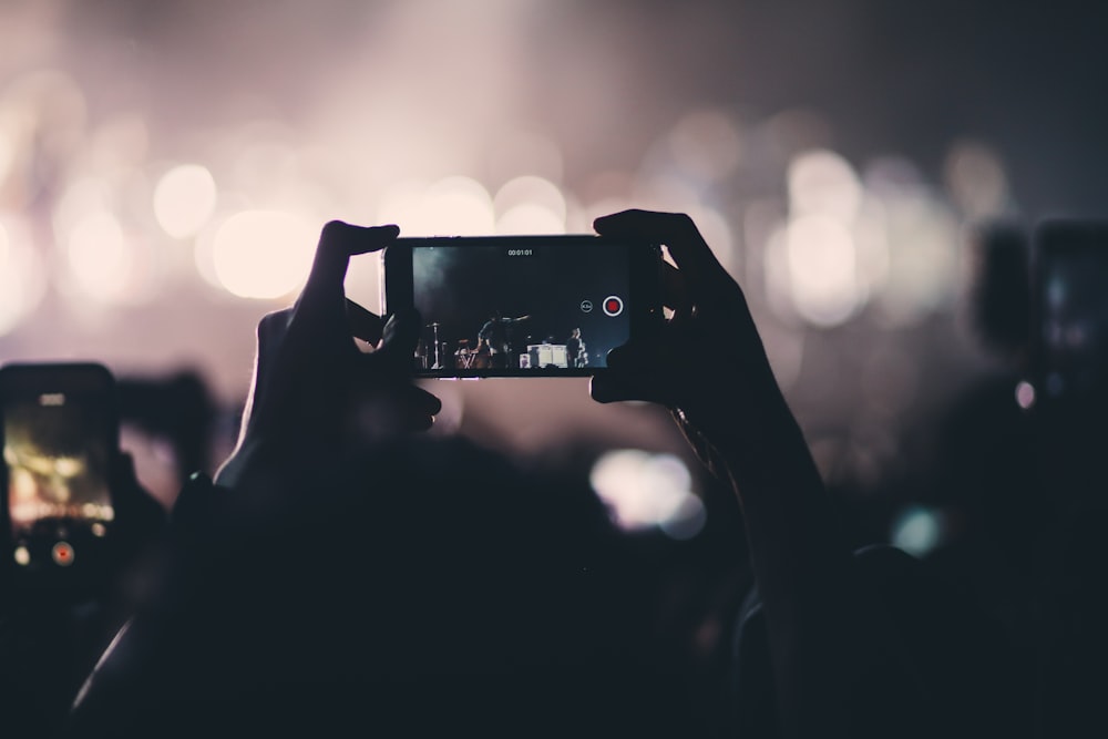 person holding phone videoing