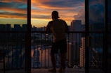 Balcony view overlooking a city skyline at sunset.