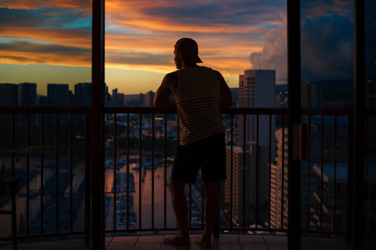 A high-rise condo balcony overlooking Edmonton's skyline at sunset.