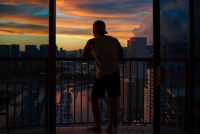 Balcony view overlooking a city skyline at sunset.