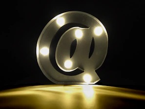 Bright neon yellow social media icons glowing against a dark background.