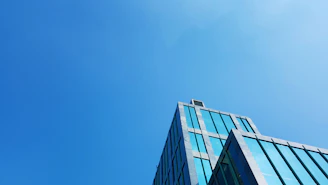 Modern commercial building with glass facade under a clear blue sky