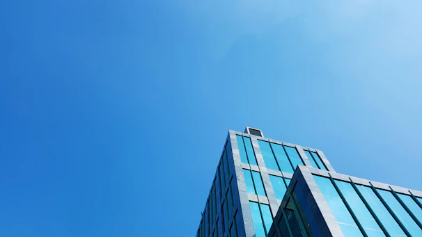 Modern commercial building with glass facade under a clear blue sky