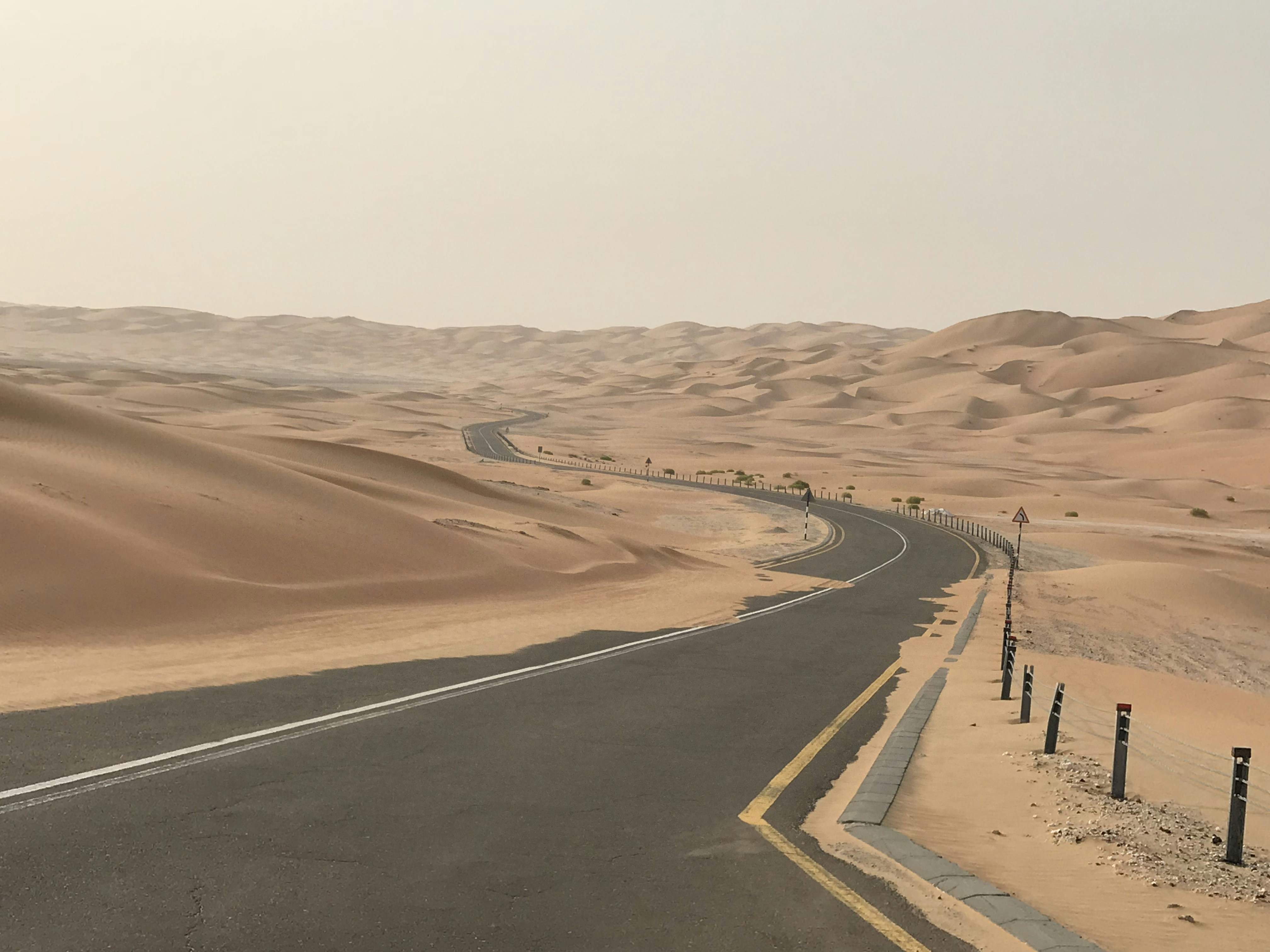 gray asphalt road on desert, We were on our way to Liwa Mureeb dune in abudhabi Liwa it was 6 am in the morning. We were looking for some super cool photos and my wife found such a breathtaking view which we capture.