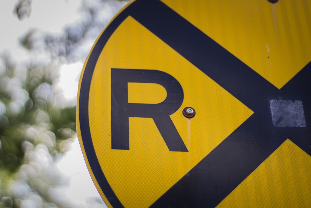 closeup photo of yellow and blue R road signage