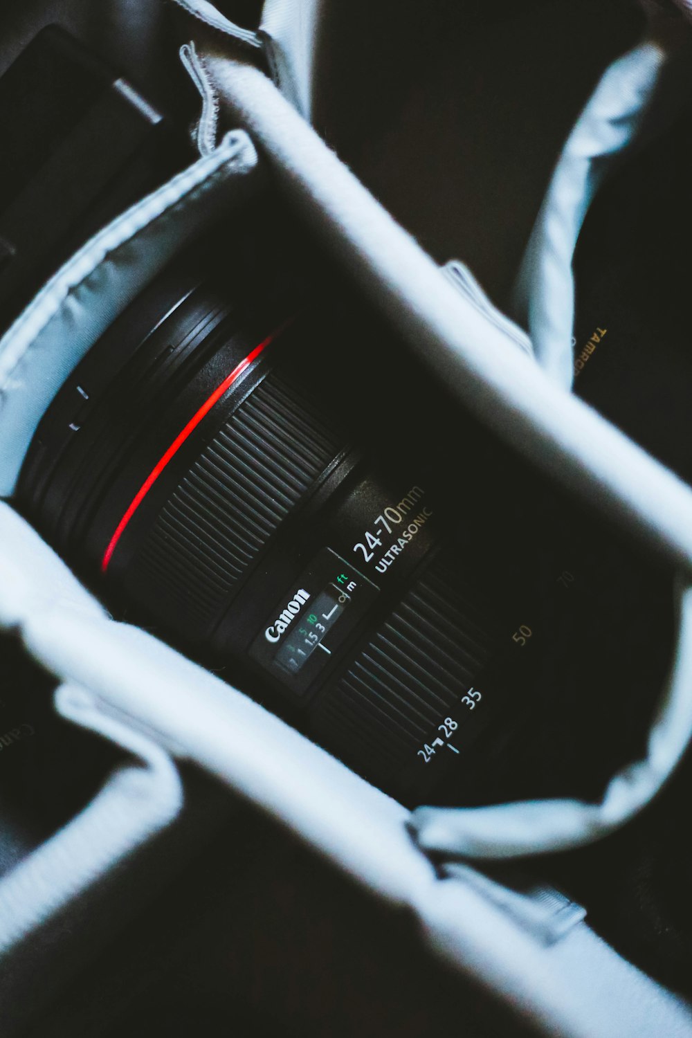 lente de zoom Canon preta e vermelha na bolsa