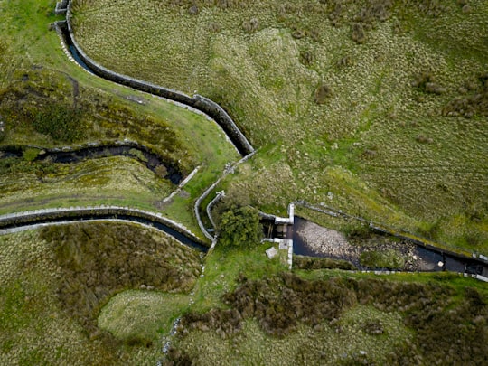 green grass field surrounding the dam in Oxenhope United Kingdom