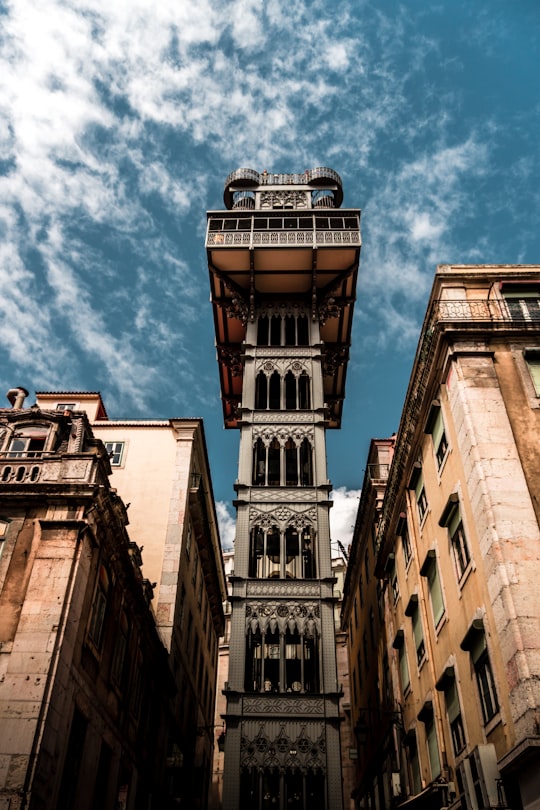 low angle photo of brown concrete building under clear sky in Lisbon Portugal