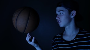 Close-up of a young athlete focusing intensely while learning basketball shooting techniques.