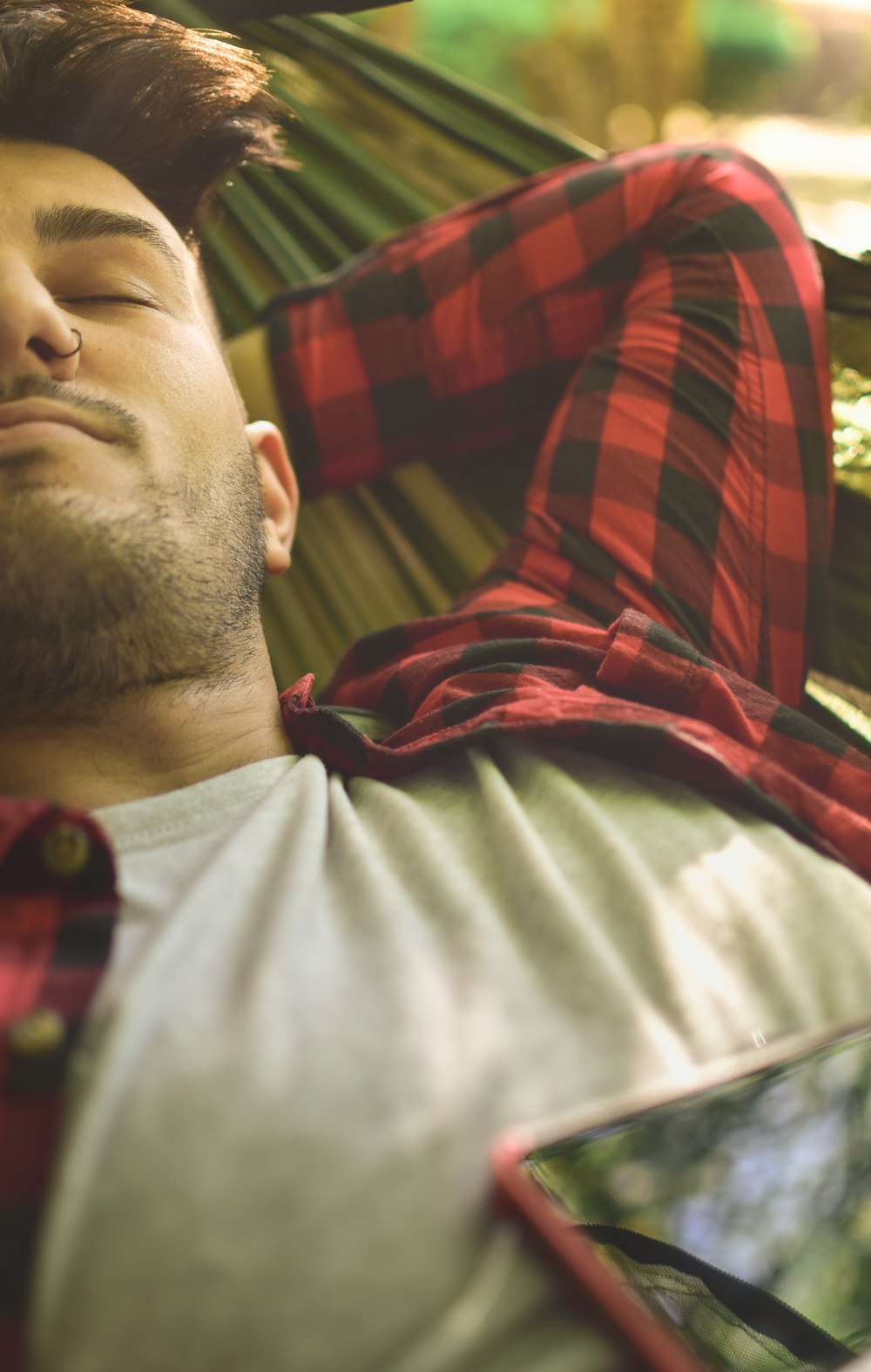 close photography of man lying on green hammock