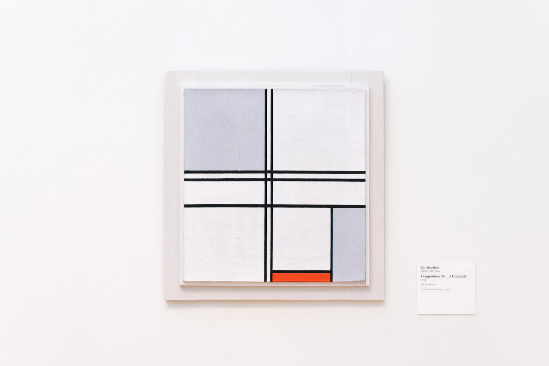 A close-up shot of a minimalist black and white abstract painting with sharp geometric lines.