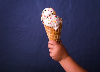 children holding brown ice cream cone with strawberry icecream