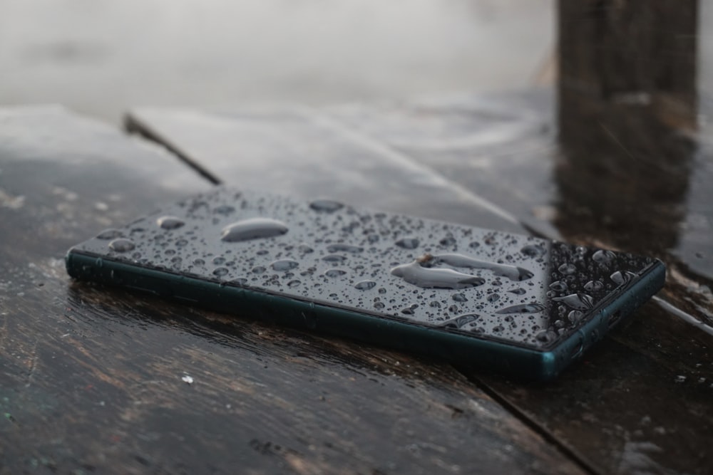 Smartphone nero sulla superficie in legno marrone