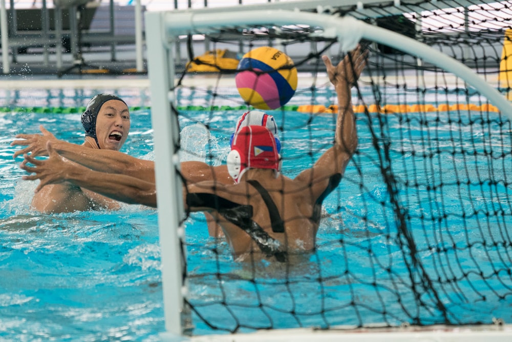 people playing volleyball in pool