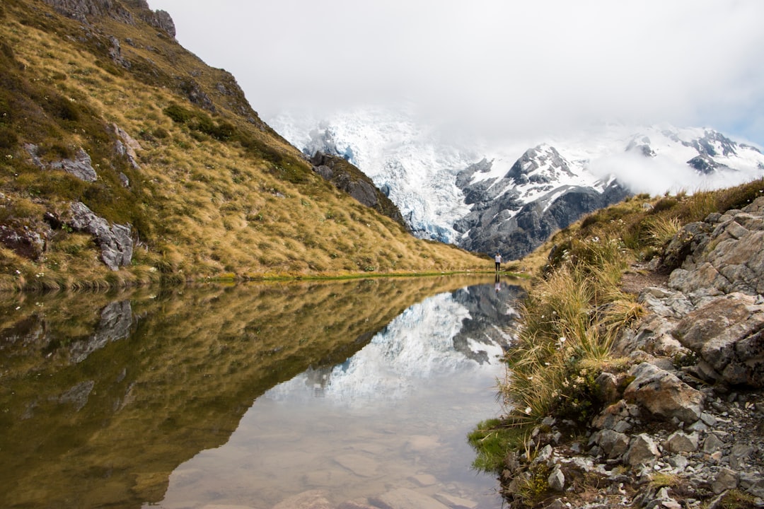 body of water in the middle of mountains during daytime