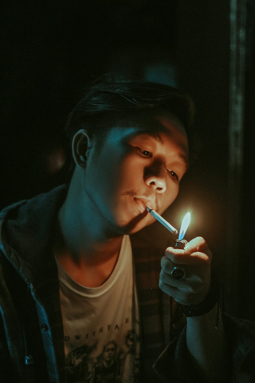 hombre encendiendo un cigarrillo en su boca