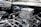 A close-up view of a polished, chrome engine with intricate mechanical components and an air filter marked with the brand 'Edelbrock'. The shiny metal surfaces reflect light, creating a glossy and detailed appearance.