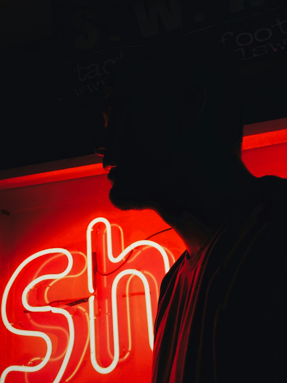 man in front of red SH neon signage