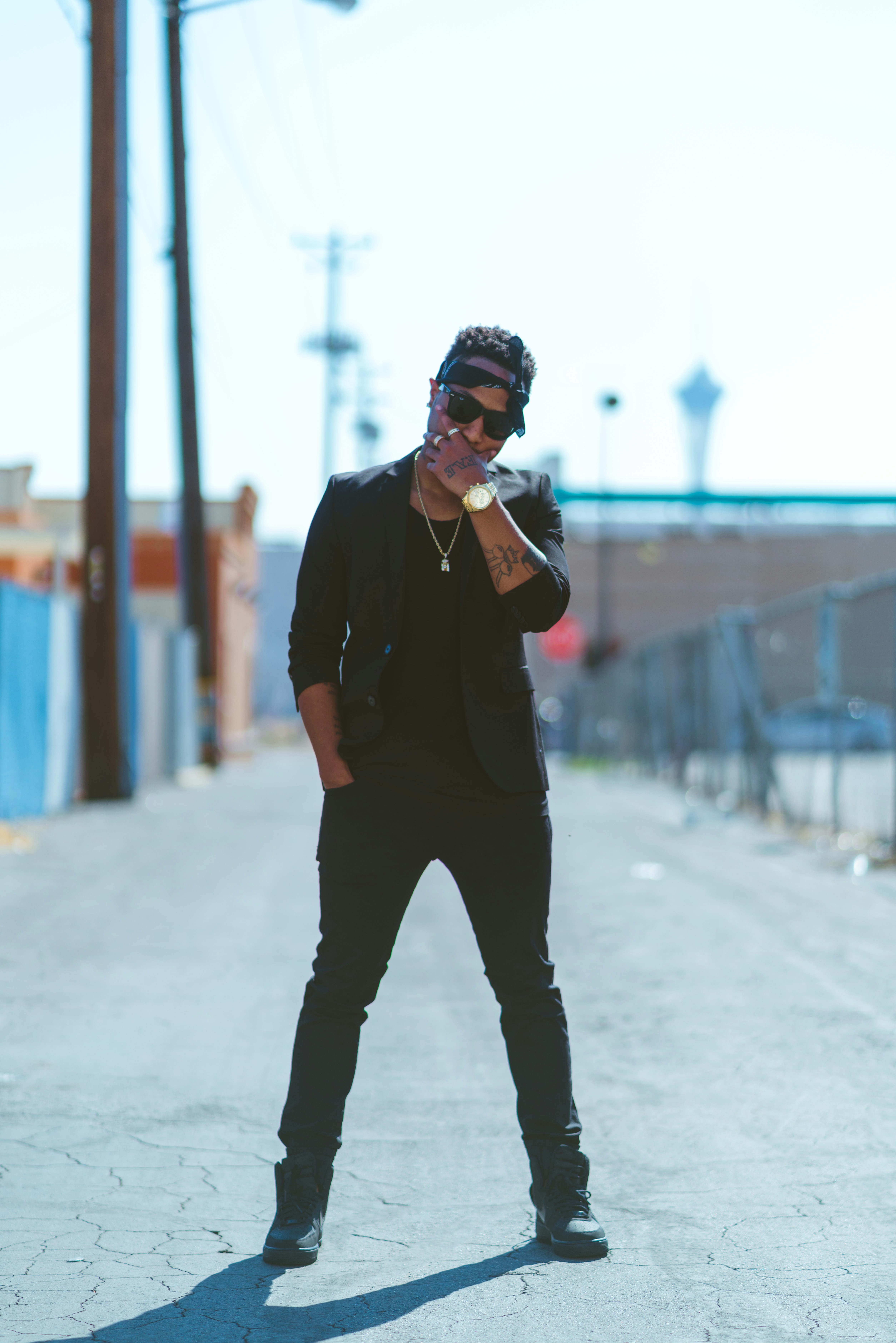 Well-dressed man in urban setting, confident stance, dark city backdrop