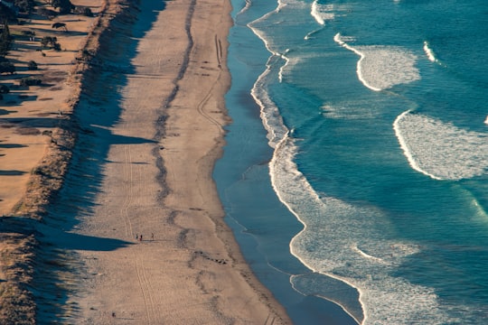 aerial photo of brown sandy beach in Pauanui New Zealand