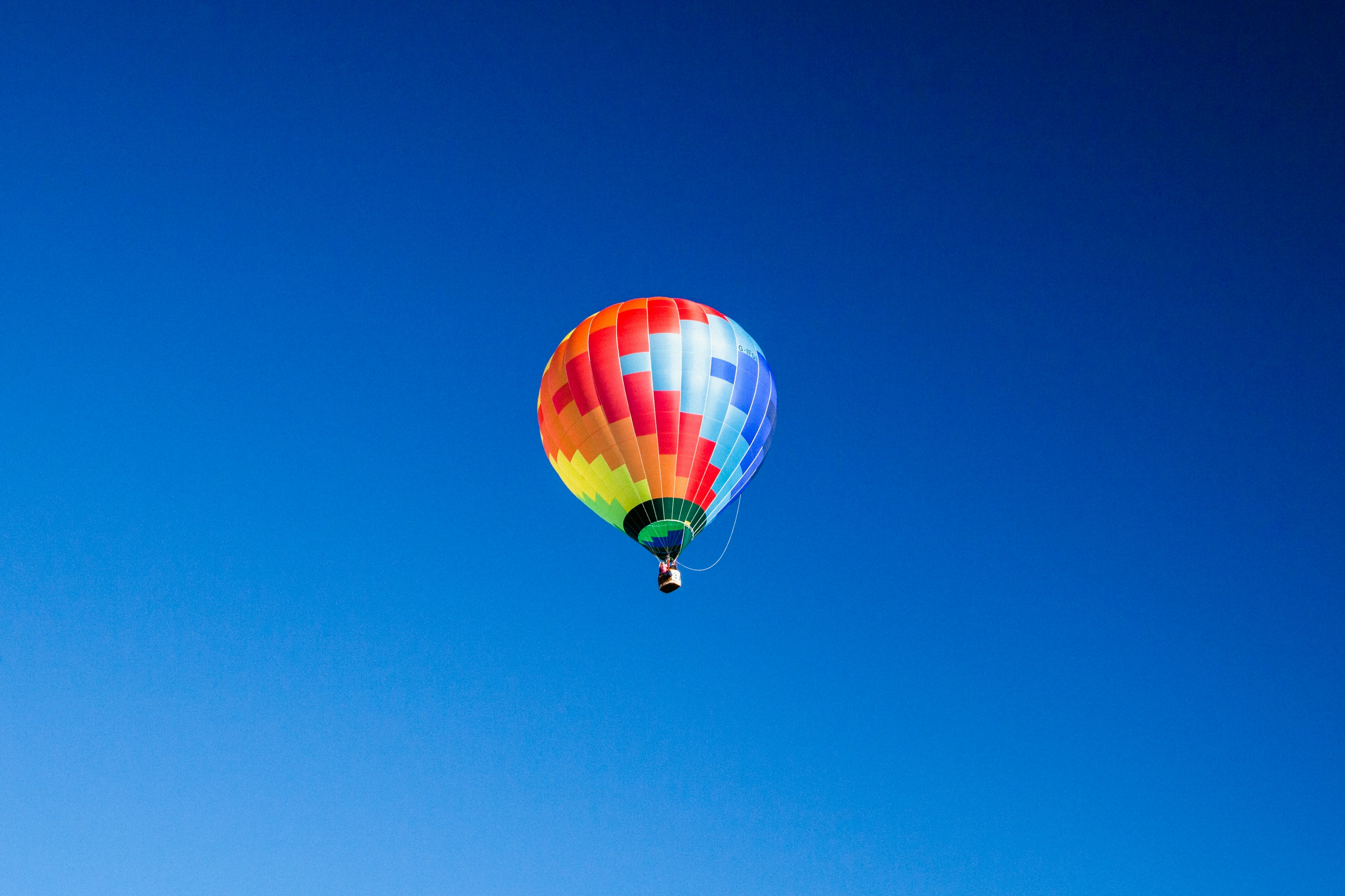 blue, orange, and red hot air balloon in mid air