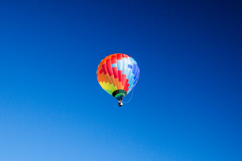 blue, orange, and red hot air balloon in mid air