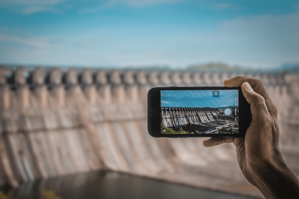 a person taking a picture of a dam