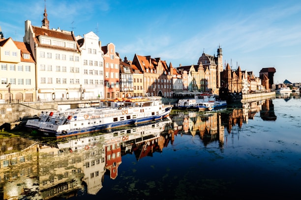 white and blue boat docked near buildings