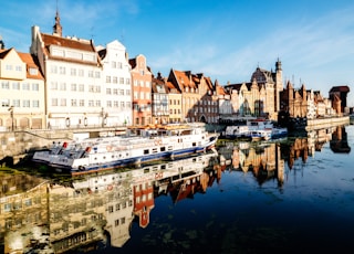 white and blue boat docked near buildings