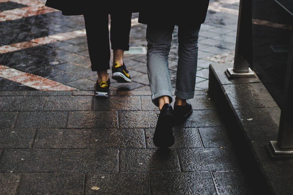 two person walking near the bench