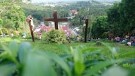 A group of people gathered in prayer around a wooden cross.