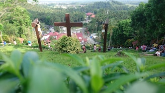 A group of people gathered in prayer around a wooden cross.