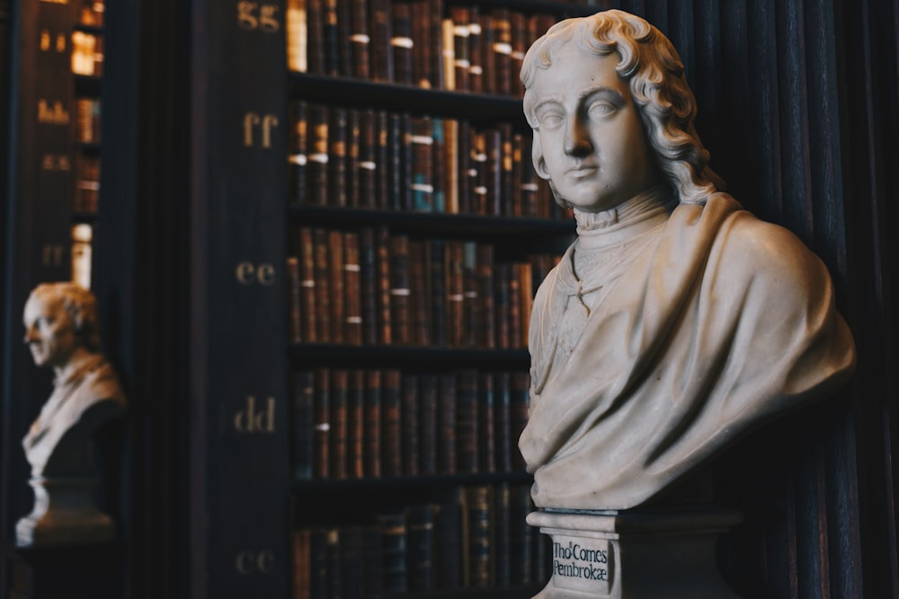 man wearing robe bust figurine near black wall