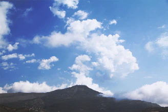 Clean horizon shot of a glacier-blue sky meeting slate grey mountain silhouettes.