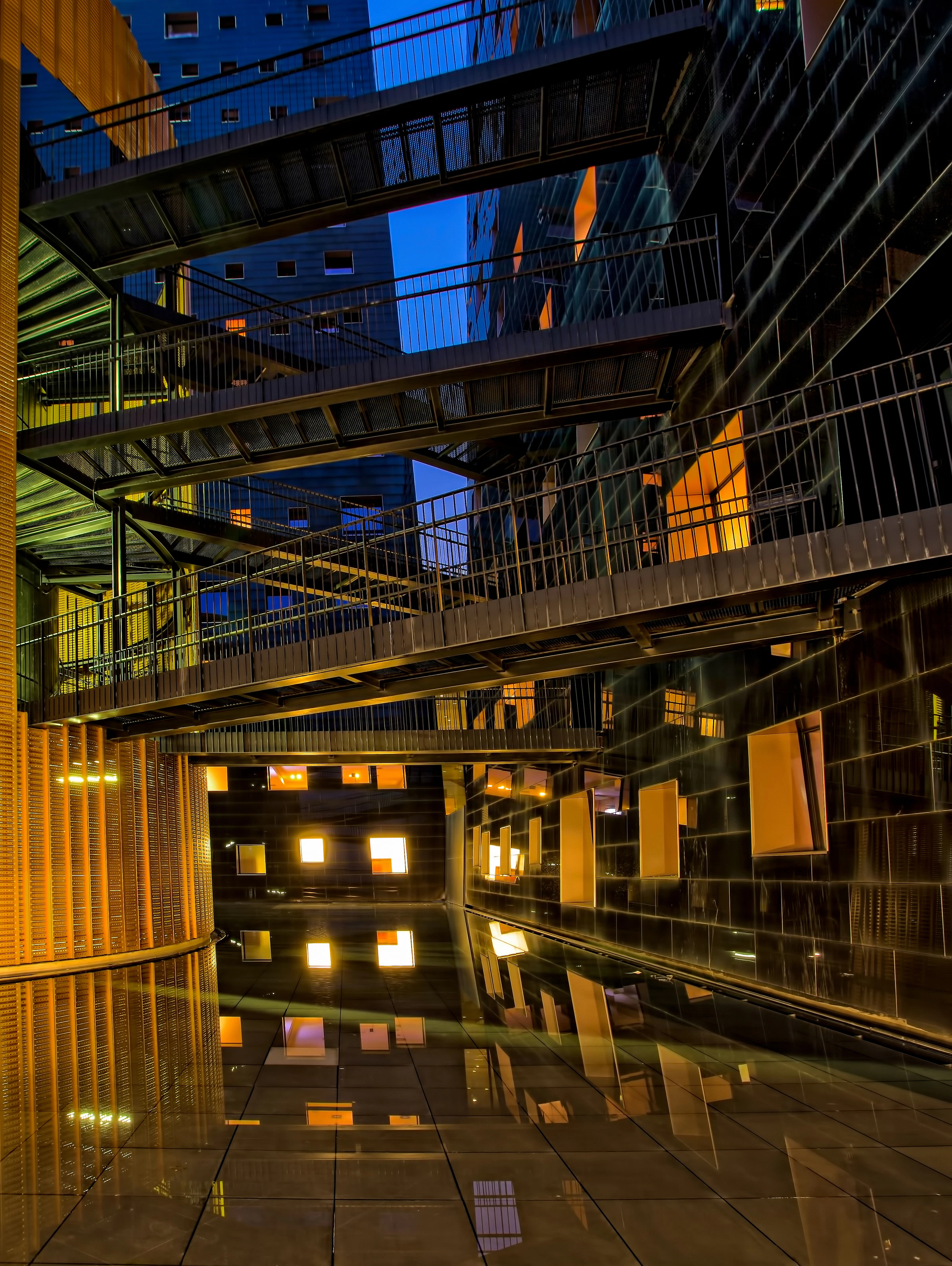 Metal walkway bridges connecting two buildings at night