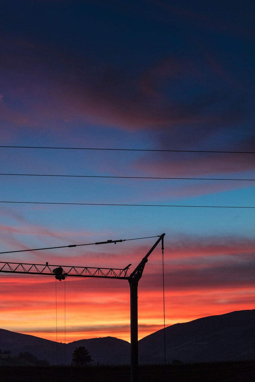 silhouette photo of electric post at golden hour