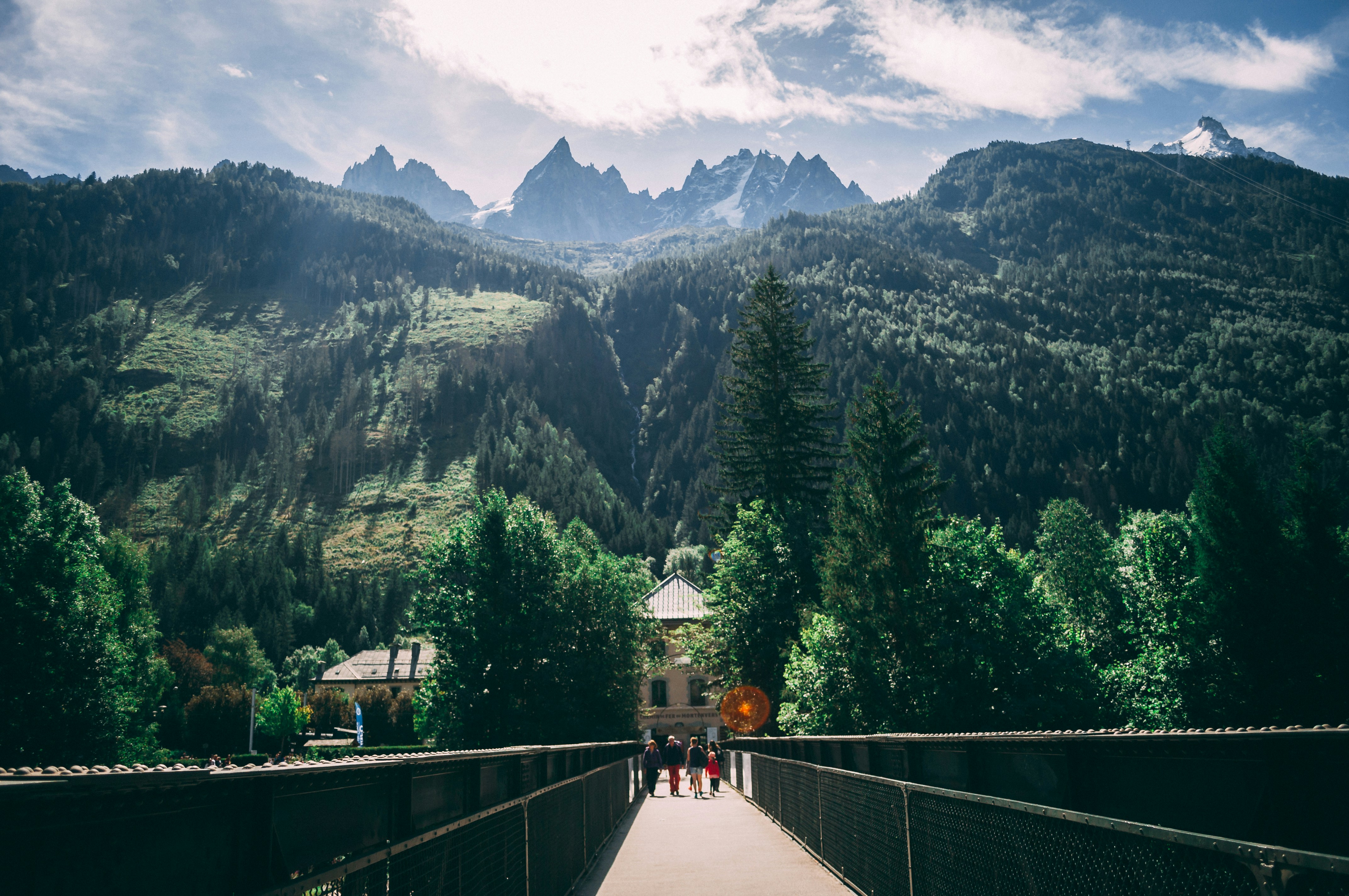 green trees beside brown concrete building, Confronted by a Mountain