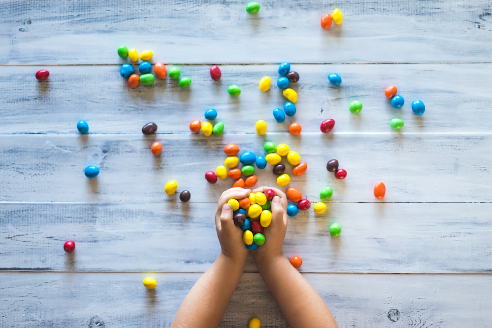 Foto selectiva de niño sosteniendo caramelos en un tablero de paletas de madera gris