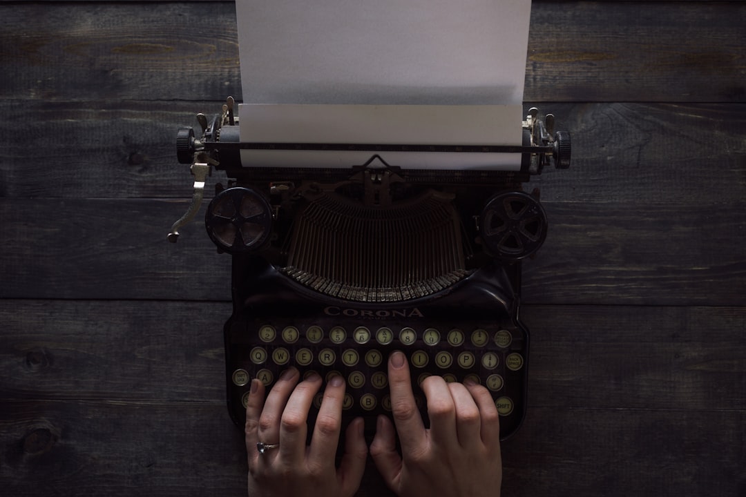 person holding white and black typewriter