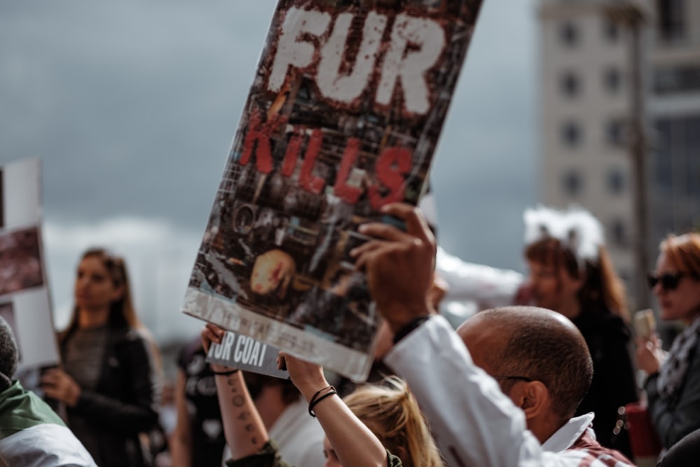 person holding Fur Kills poster